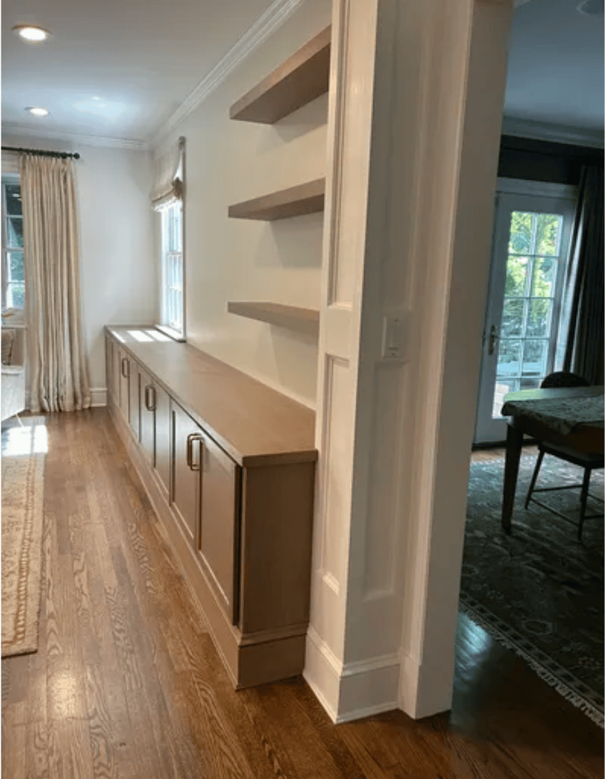 Photo of white oak base cabinets and floating shelves in a home.